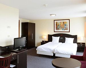 Elegante kamer met zithoek in Amrth Grand Hotel de lEmpereur, Maastricht, ideaal voor een ontspannen vakantie.