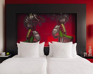 Comfortabel bed met kunstwerk in Designhotel Maastricht, vakantieverblijf in Limburg.