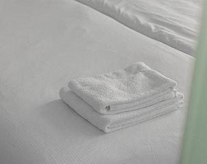 Zachte handdoeken opgemaakt op bed in Hotel de la Bourse, comfortabel verblijf in Zuid Limburg, Maastricht.