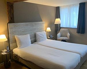 Stijlvolle slaapkamer met houten balken in Hotel Au Quartier, vakantieappartement in Maastricht, Limburg.