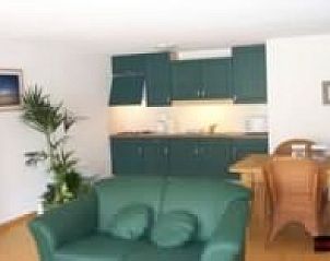 Gemtlicher Innenraum von De Zandbult in Oost-Vlieland, Vlieland, mit grner Kche und gemtlicher Sitzecke auf den Watteninseln.