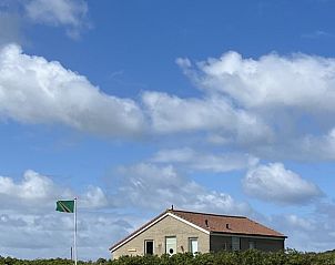 Anders Wad(t) vakantiehuis op Vlieland met groene omgeving en blauwe lucht.