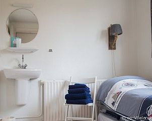 Stijlvolle eenpersoonskamer in Vosseburcht appartement, Oost-Vlieland, met wastafel en frisse handdoeken.
