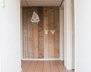 Entreehal van Vosseburcht vakantieverblijf, Oost-Vlieland, met houten wanddecoratie.