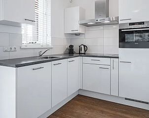 Moderne keuken in Vlieduyn 2-4-persoons appartement, Oost-Vlieland, met strakke witte kasten.