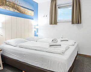 Ruime slaapkamer in Vlieduyn 2-4-persoons appartement, Oost-Vlieland, met tweepersoonsbed en stranddecoratie.