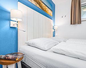 Slaapkamer in Vlieduyn 2-4-persoons appartement, Oost-Vlieland, met sfeervolle verlichting.