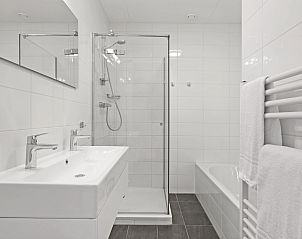 Eethoek in Vlieduyn 2-persoons appartement, Oost-Vlieland, met houten tafel en comfortabele stoelen.