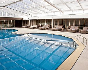 Overdekt zwembad met ligstoelen in WestCord Strandhotel Seeduyn, Vlieland, Waddeneilanden.