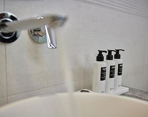 Luxe badkamer met wastafel en verzorgingsproducten in WestCord Hotel de Wadden, Vlieland