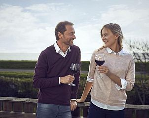 Gezellig stel geniet van wijn op terras bij WestCord Hotel de Wadden, Vlieland