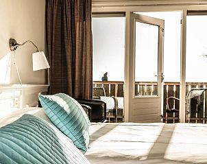 Lichte slaapkamer in Loods Hotel Vlieland, vakantieappartement op Vlieland, met toegang tot balkon.