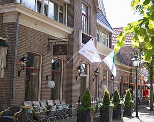 Straatbeeld voor Loods Hotel Vlieland, vakantieappartement op Vlieland, met historische architectuur.