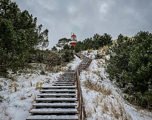 Sneeuwbedekte trap naar vuurtoren dichtbij Loods Hotel Vlieland, vakantieappartement op Vlieland.