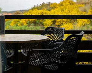 Balkon van Vlierijck vakantieappartement op Vlieland met uitzicht op natuur.