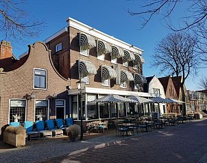 Badhotel Bruin, Vlieland, vakantieappartement met uitnodigend terras en klassieke architectuur.