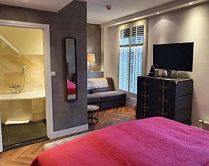 Stijlvolle suite in Badhotel Bruin, Vlieland, met moderne badkamer en gezellige zithoek.