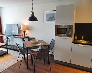 Gezellige binnenruimte in Badhotel Bruin, Vlieland, met kitchenette en eetgedeelte.
