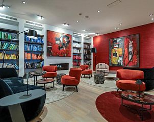 Lichte woonkamer in Badhotel Bruin, Vlieland, met moderne inrichting en balkon.