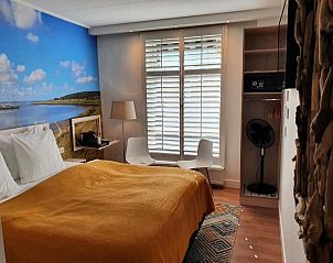 Gezellige slaapkamer in Badhotel Bruin, Vlieland, met comfortabel bed en serene sfeer.