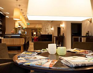 Gezellige leeshoek in Badhotel Bruin, Vlieland, met tijdschriften en comfortabele stoelen.