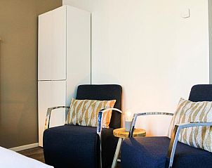 Gezellige zithoek in Hotel DoniaState, vakantieappartement op Vlieland, met comfortabele stoelen voor ontspanning.