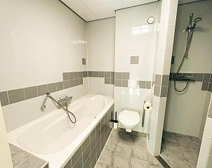 Luxe badkamer met ligbad in Hotel DoniaState, vakantieappartement op Vlieland, ideaal voor een verfrissende pauze.