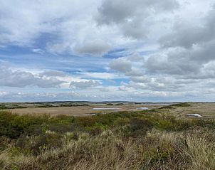 Uitzicht over de duinen en zee op Vlieland, een schilderachtig landschap nabij Hotel DoniaState, vakantieappartement op de Waddeneilanden.