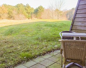 Terras met uitzicht op het groen bij Hotel DoniaState, vakantieappartement op Vlieland, ideaal voor een rustige ochtend.
