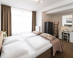 Comfortabele slaapkamer met rustieke details in Het Vlielandhotel, Vlieland.