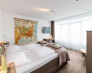 Stijlvolle slaapkamer met wereldkaart decor in Het Vlielandhotel, Vlieland.