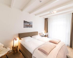 Gezellige slaapkamer met houten details in Het Vlielandhotel, Vlieland.