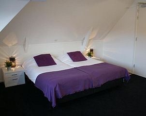 Slaapkamer met paarse accenten in De Herbergh van Flielant, vakantieappartement in Vlieland, Waddeneilanden.