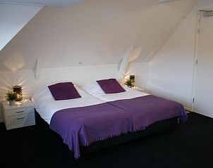 Comfortabele slaapkamer met paarse accenten in De Herbergh van Flielant, vakantieappartement op Vlieland, Waddeneilanden.