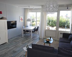 Lichte eetruimte in Duinzicht appartement, Buren, Ameland met moderne inrichting.