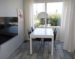 Moderne eethoek in Duinzicht appartement, Buren, Ameland met uitzicht op de tuin.