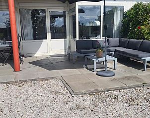 Buitenruimte van Duinzicht appartement, Buren, Ameland met zithoek en parasol.