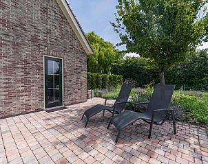 Zonnig terras van Villa Magnolia, vakantiehuis in Oostkapelle, Walcheren, perfect voor ontspanning in de natuur.