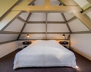 Zolderkamer in Villa Magnolia, vakantiehuis in Oostkapelle, Walcheren, met houten balken en knusse sfeer.
