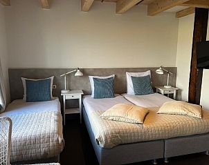 Comfortabele slaapkamer in Hotel Posthuys Vlieland, Oost, met drie bedden op Waddeneilanden.