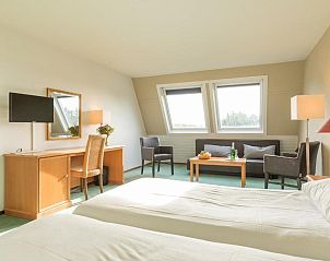 Ruime slaapkamer in Fletcher Resort-Hotel Amelander Kaap, Hollum, Ameland met comfortabele bedden en modern interieur.