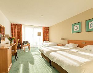 Familiekamer in Fletcher Resort-Hotel Amelander Kaap, Hollum, Ameland met comfortabele bedden en zonnig interieur.