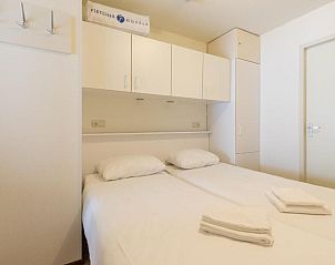 Compacte slaapkamer in Fletcher Resort-Hotel Amelander Kaap, Hollum, Ameland met praktische opbergruimte.