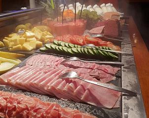 Comfortabele slaapkamer in Hotel Restaurant Dolores, Hollum, Ameland met groot raam en sfeervolle verlichting.