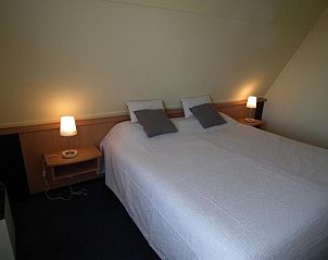 Gemtliches Schlafzimmer in der Wohnung Hollumerduinen, Hollum, Ameland mit bequemen Betten und stimmungsvoller Beleuchtung.