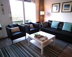 Stilvolle Sitzecke in der Wohnung Hollumerduinen, Hollum, Ameland mit bequemen Sthlen und dekorativen Elementen.