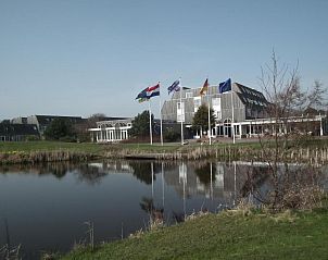 Hollumerduinen Wohnanlage in Hollum, Ameland mit Teich und Fahnen, ruhige Umgebung.