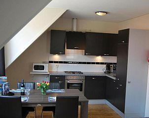 Moderne keuken in Wijnberg Appartementen, Hollum, Ameland met eettafel en apparatuur.