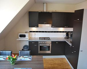 Moderne keuken in Wijnberg Appartementen, Hollum, Ameland met eettafel.
