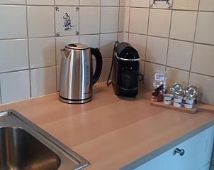 Moderne keuken met waterkoker en koffiezetapparaat in Bij De Vuurtoren appartement, Hollum, Ameland.